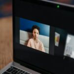 A young African American girl participates in an online class at home on a laptop.