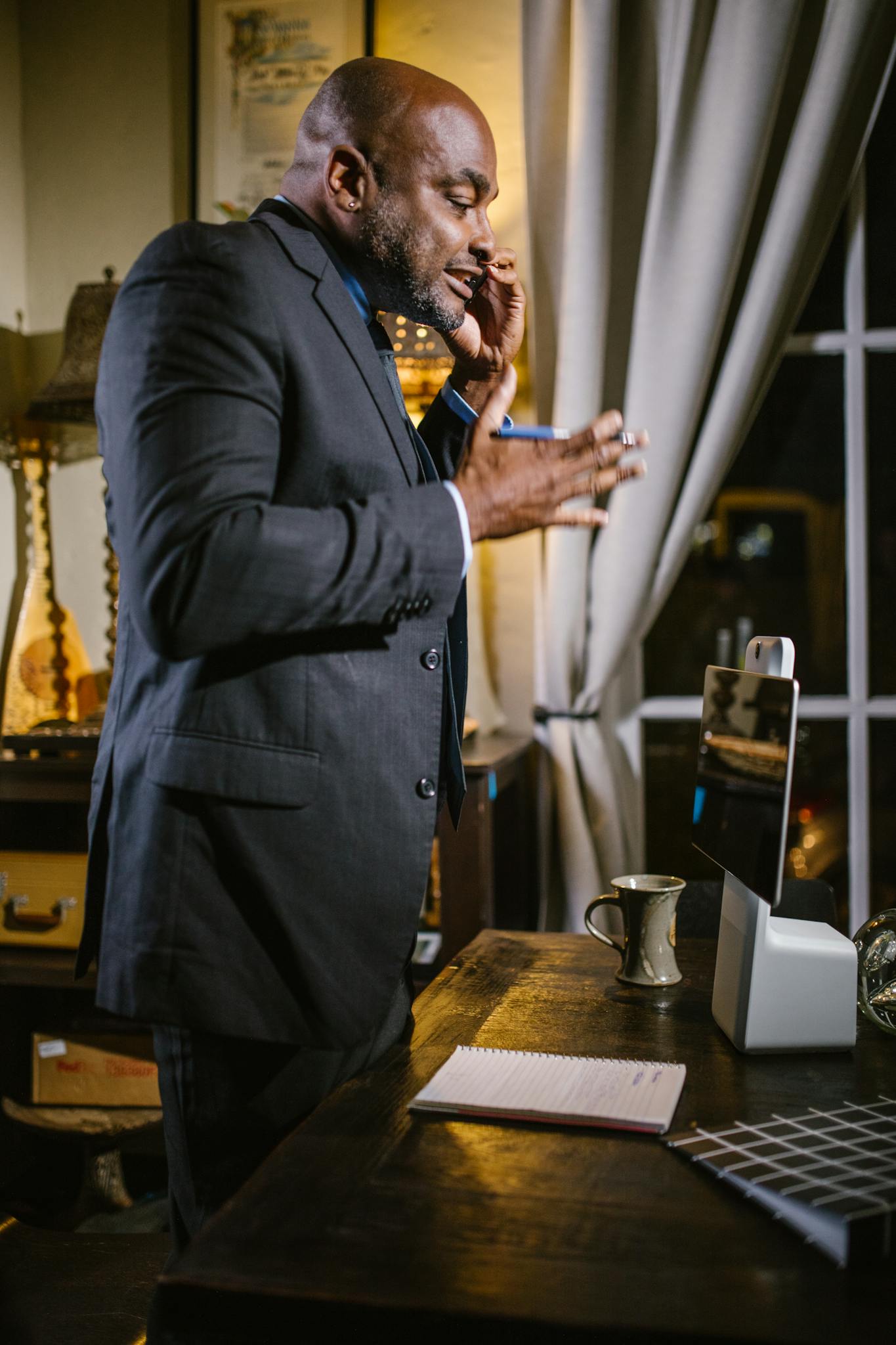 Professional man in a suit conducting a video call in a home office setting.